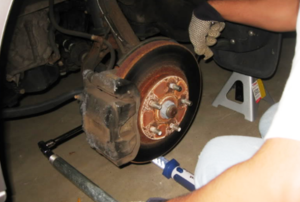 A person works on a brake rotor.
