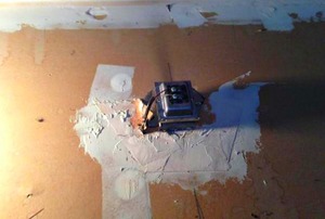 A mysterious electrical contraption installed on the back of a wall. (It's a doorbell.)
