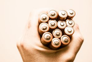 a hand holding batteries