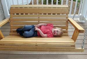 Child on a wooden porch swing