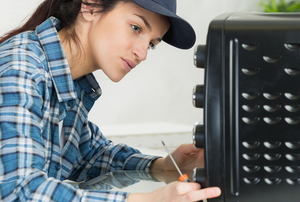 woman examining toaster oven with a screwdriver