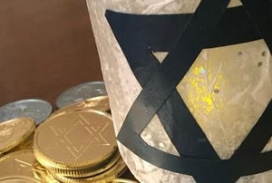A Mason jar decorated with a Star of David surrounded by Hanukkah-themed candy. 