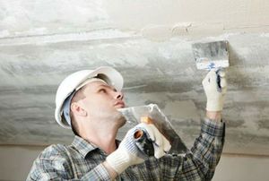 Construction worker plastering the ceiling