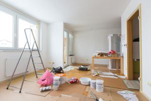 A room in the process of being renovated with a ladder and tools in it.