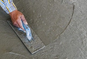 a hand smoothing out self leveling concrete