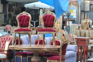 A grouping of antique and vintage furniture in a flea market.