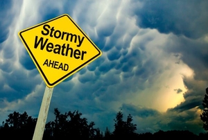Stormy sky with a traffic sign stating "Stormy weather ahead."