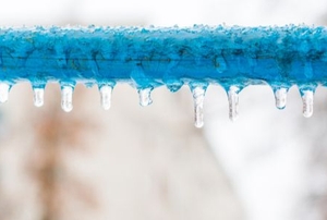 blue pipe frozen over with small icicles
