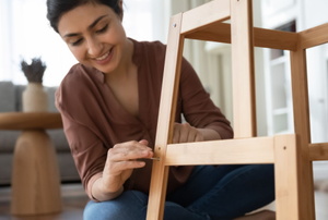 smiling woman building furniture