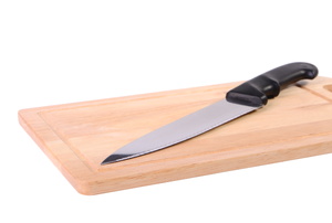 A butcher block with a knife on it.