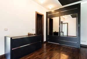 room with black dresser and large sliding mirrored closet doors