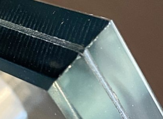 thick double sheet of soundproof glass seen from the corner