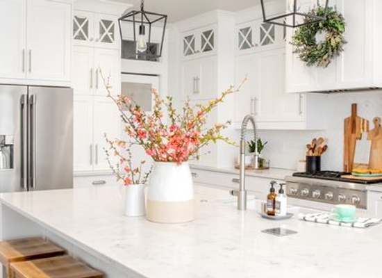 light, open farmhouse kitchen with sink island featuring pink flowers in vases