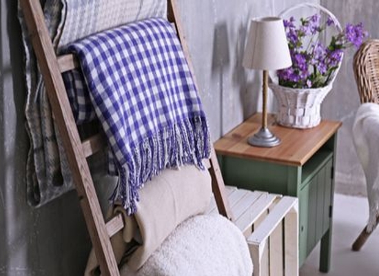 blanket ladder with blankets near wicker chair