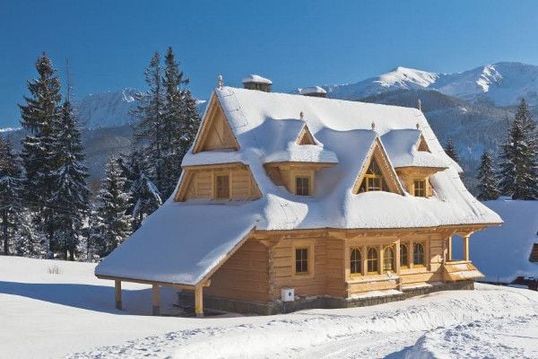 A mountain home surrounded by snow. 