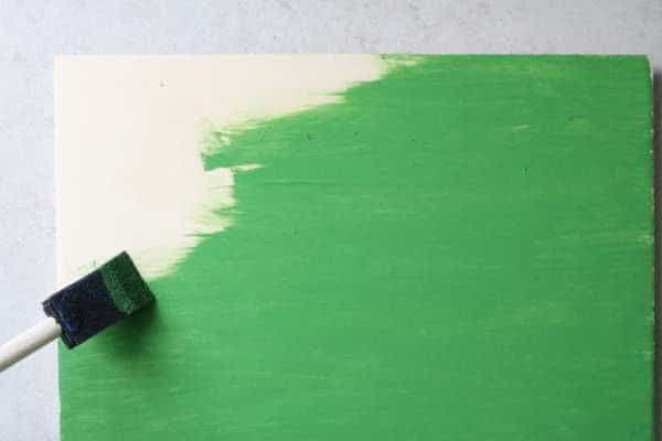 A box being painted with green paint. 