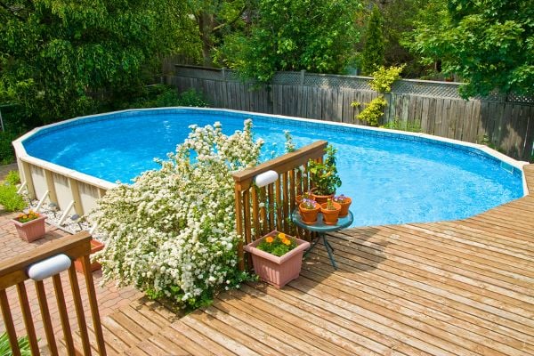 An above-ground pool next to a deck. 