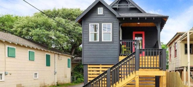 a narrow house with wooden staircase and siding