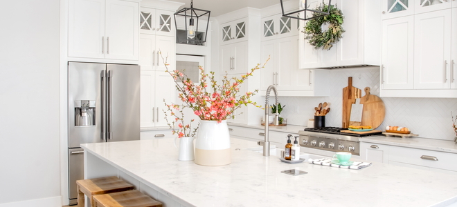 light, open farmhouse kitchen with sink island featuring pink flowers in vases
