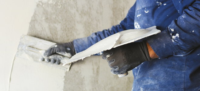 man applying plaster to a wall