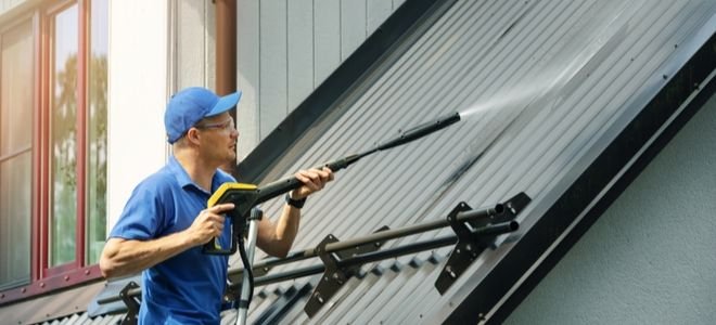 A man cleans a roof.