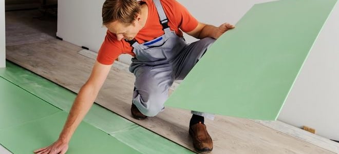 person installing underlayment for laminate flooring