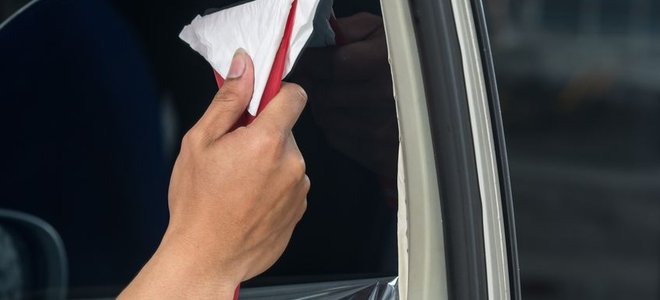 Smoothing out a new application of car window tint.