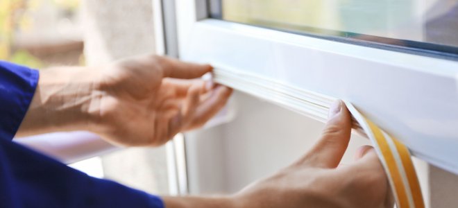 A man adds weather stripping.