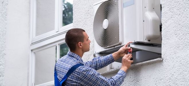 man working on window air conditioner