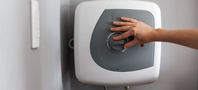 hand turning dial on modern water heater