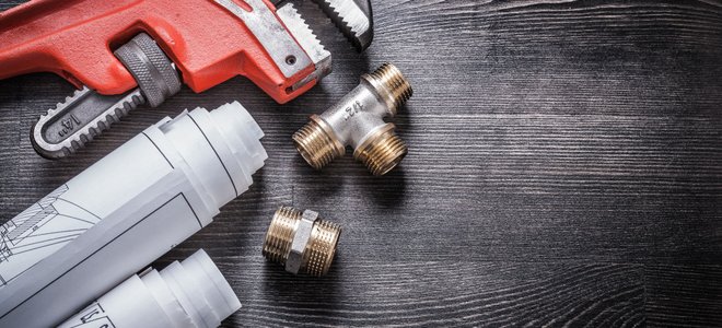 A monkey wrench against a gray background.