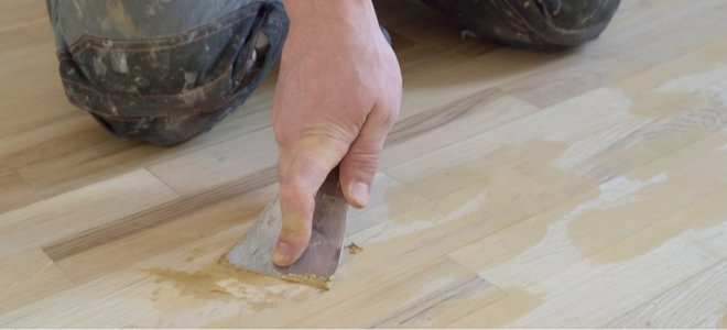 applying wood putty to a floor