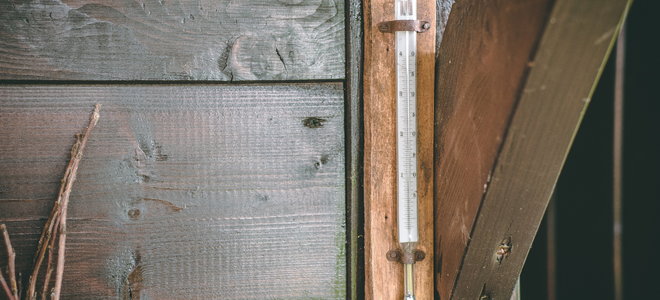 A thermometer on the side of a house.