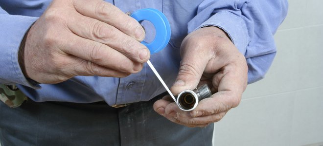 A man uses blue plumber's tape.