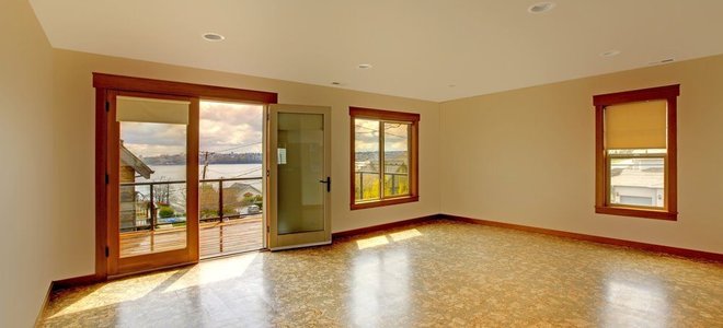 empty rooms with windows, open door, and cork floors