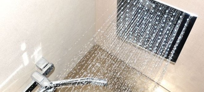 A ceiling mount shower head spraying water down.