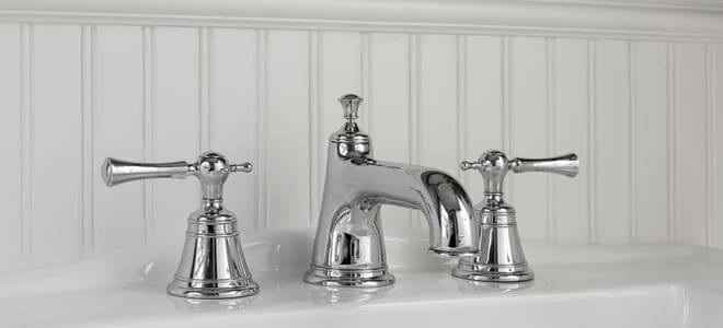 silver bathroom faucets mounted on a white sink