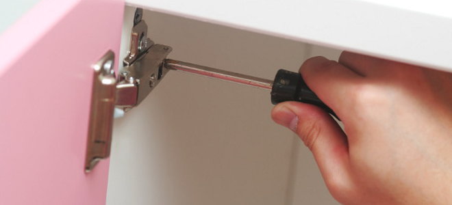 screwing in a cabinet hinge