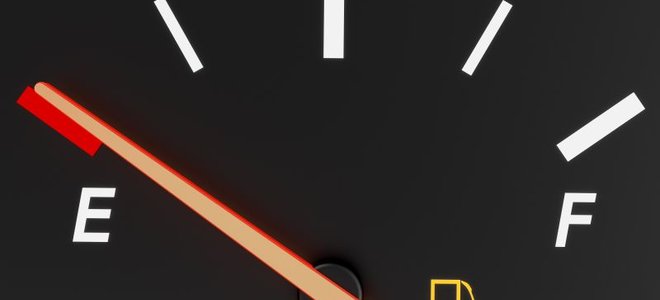 An empty gas gauge with the fuel light on.