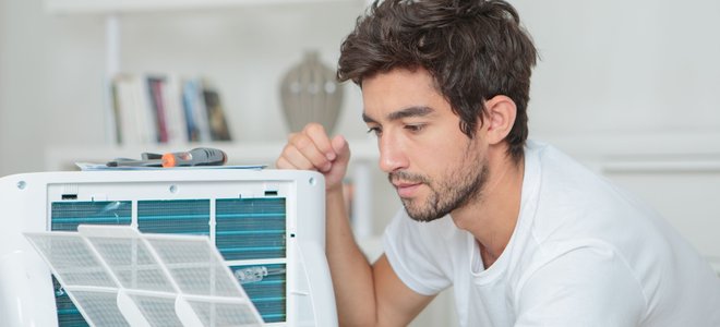 A man sets up a room AC unit.