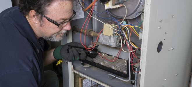 A man works on a furnace.