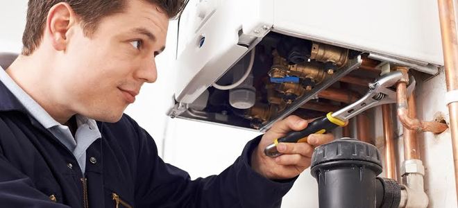 A handyman working on a boiler.