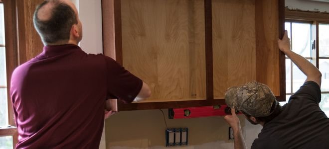 two men installing kitchen cabinets