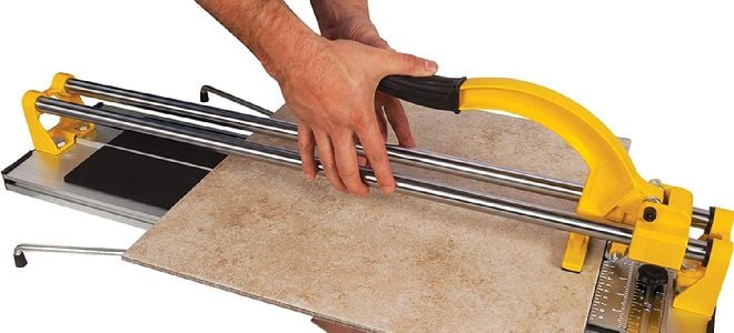 hands using snap tile cutter device to break tile