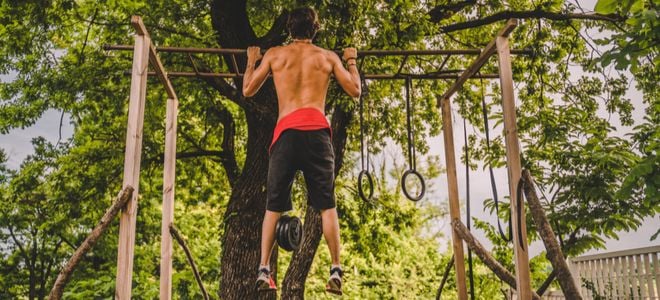 person doing pull ups on an outdoor gym setup
