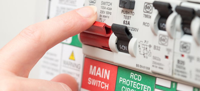 finger on main red power switch for circuit breaker