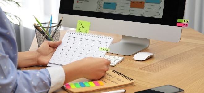 woman organizing her calendar next to a computer