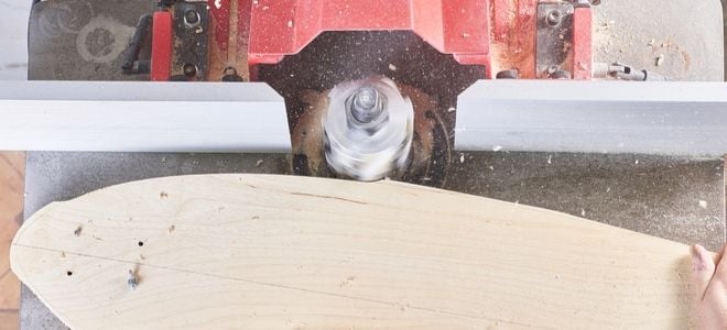 sawing the edge of a hand made skateboard