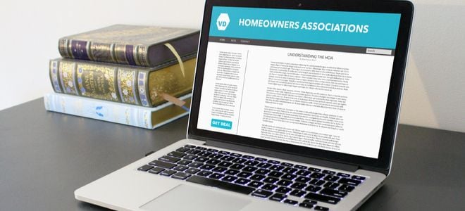 home owners association bylaws on a laptop with books