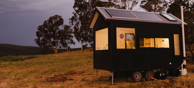 tiny home with solar panels and lights on